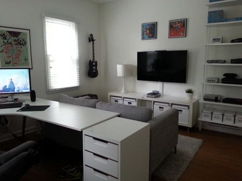 Black and white game room with a desk & couch Gaming Room Pc And Tv, Video Game Area In Living Room, Work And Game Room, Pc Tv Setup, Office And Gaming Room Combo, Small Office Game Room Combo, Gaming Area In Living Room, Game Room And Office Combo, Office Game Room Combo