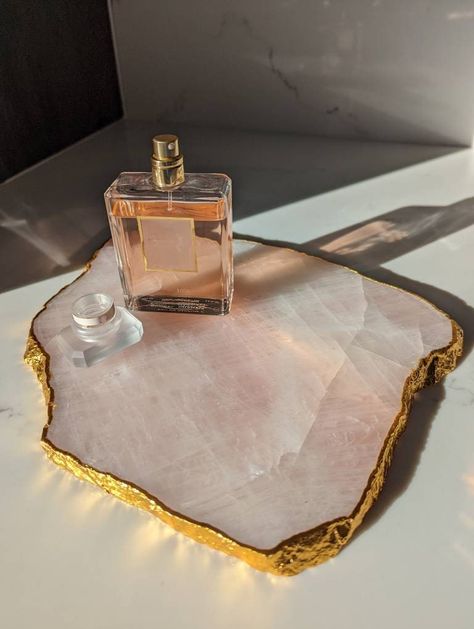 A large natural rose quartz platter edged with gold plating. Created to be a beautiful addition to any home or perfect as a gift or a treat for yourself. These can be used as: - cheese tray - home decor  - jewellery display / holder - mini charcuterie board - wedding table set Approx 13inches x 7inches. Each platter will be unique in size, colour, translucency and shape due to the nature of the stone - no two will be exactly the same! Crystals In Home Decor, Rose Quartz Bedroom, Rose Quartz Decor, Rose Gold Office Decor, Charcuterie Board Wedding, Tray Charcuterie Board, Mini Charcuterie, Rose Gold Office, Fall Apartment Decor