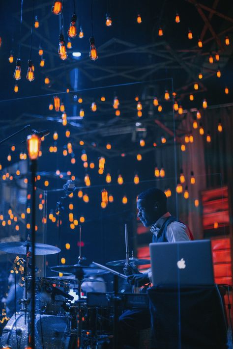 Phil Bowdle from West Ridge Church in Dallas, GA brings us this super warm look.They wanted to create a warm look on the stage that would create a lot of depth and texture. So the team used rusted panels of metal, wood, and a ton of Edison bulbs that gave them a variety of looks that they could use. They tied in the chandeliers that they made for the stage and installed them in their atrium. Concert Lighting Design, Dark Stage Lighting, Church Led Screen Stage Design, Concert Stage Lighting, Blue Stage Lighting, Stage Lighting Design, Concert Lights, Small Hall, Summer Fest