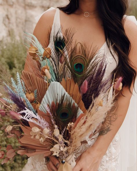 SSoft pastel accents and earthy tones come together in this unique bouquet, featuring dehydrated foliage and peacock feathers for a natural and  bold vibe. Boho Peacock Wedding, Wedding Flowers Bride Bouquets, Peacock Feather Bouquet, Peacock Wedding Flowers, Peacock Wedding Colors, Peacock Wedding Inspiration, Peacock Theme Wedding, Peacock Wedding Ideas, Wedding Flowers Bride