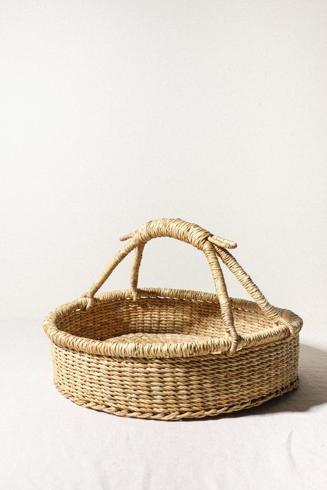 This Harvest basket is great for holding fresh produce from the market or for harvesting from your own garden! Beautifully displays produce and eggs in your kitchen. From our friends at Woven Worldwide: We have direct relationships with four-generation artisan weavers that craft up to 4 days a week, giving families the time to sustain communities. Made from Elephant Grass, 13" x 13" x 8" (without handles: 4" tall) Made in Ghana Woven Worldwide is a women-owned small business based in Toronto, C Egg Baskets, Market Basket, Basket With Handle Decor Ideas, Berry Basket, Woven Basket, Handwoven Market Basket Bag, Natural Handwoven Basket Bag, Woven Grocery Basket, Eco-friendly Open Weave Basket Bag