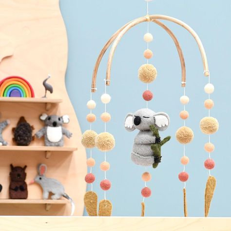 Tara Treasures on Instagram: “This 🐨 baby mobile features a sleepy koala hugging a tree branch, beautiful pompoms in earthy colours and eucalyptus leaves. . The frame is…” Baby Mobile Ideas, Koala Nursery, Aussie Icons, Forest Critters, Handmade Mobile, Pet Frame, Mobile Hanging, Animals Forest, Cot Mobile