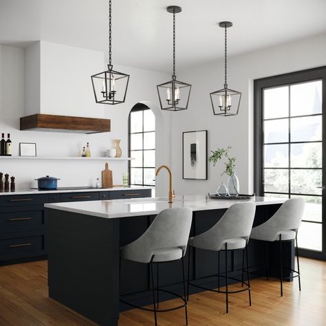 The Anover Collection of dramatic, open frame pendant lights is inspired by a classic silhouette and enhanced with modern detailing and finishes. The Anover 10" Wide Lantern Pendant Light features three candelabra lights set in a timeless open metal frame, finished in a striking matte black. The entire structure is suspended by a beautiful, adjustable matching chain and circular canopy. Each component has been thoughtfully styled and produced; including a delicately tiered canopy, seamless body Black Iron Light Fixtures, 3 Pendant Lights Over Island Black, Black Kitchen Lights Over Island, Pendent Lighting Over Island Black, Black Pendant Light Kitchen Islands, Simple Island Lighting, Matte Black Pendant Lights Kitchen, Black Kitchen Island Pendant Lights, Beautiful Bungalows