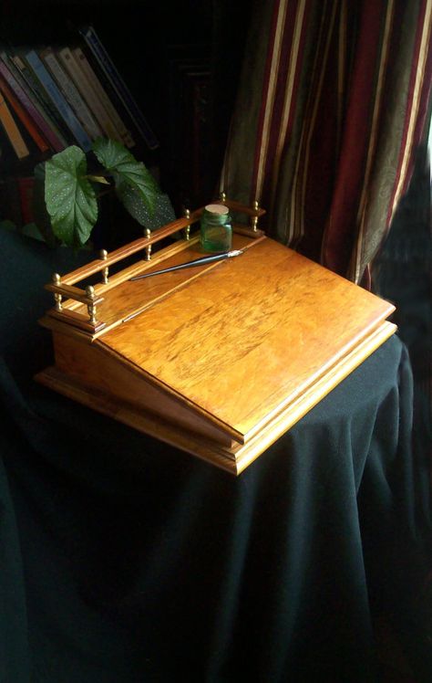 This vintage lap desk will be a gorgeous addition to your office or library. It probably dates from the 1950s (it is put together with old style flat head screws) but it looks new! It has a decorative railing with brass fittings and a hinged writing surface with storage underneath. It measures eighteen inches wide and fourteen inches deep. It is seven inches high (with rail). The storage section is about eleven inches deep and almost three inches high (at the back). Please Note: vintage items... Wood Lap Desk, Writing Slope, Writers Desk, Writing Desks, Lap Desk, Writing Space, Stationery Storage, Brass Fittings, Old Style