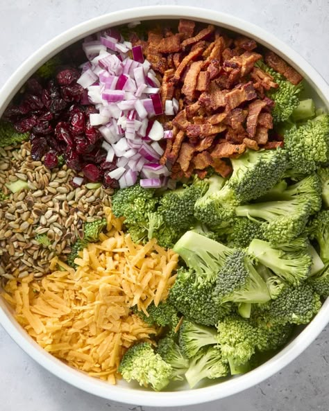 overhead shot of all the ingredients of the broccoli salad organized in a circle around a large white bowl. Broccoli Bacon Salad, Dinners Crockpot, Trending Food Recipes, Delicious Magazine Recipes, Popular Food Recipes, Healthy Broccoli Salad, Broccoli Bacon, Trending Food, Broccoli Salad Bacon