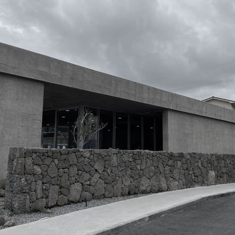 A monochromatic palette of concrete, honed basalt, and timber on both the interior and exterior of the space. Concrete Finish, Monochromatic Palette, Space Design, The Space, Interior And Exterior, Garage Doors, Cafe, Exterior, Interior Design