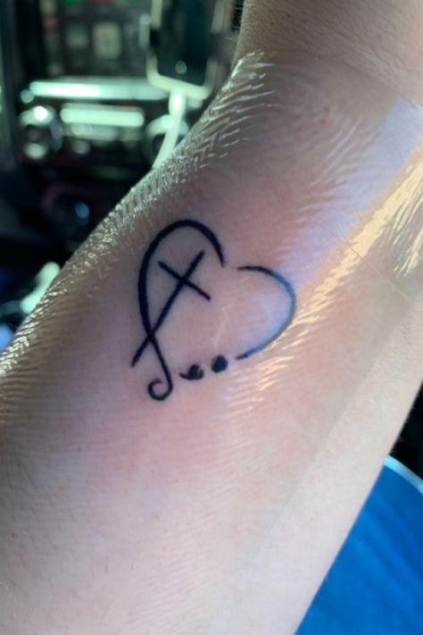 25 Amazing Heart Tattoos For Women To Try In 2023 Semicolon Tattoo Faith, Small Heart Semicolon Tattoo, Heart Faith Tattoo, Small Heart Memorial Tattoo, Faith Tattoo With Semicolon, Heart With Semicolon Tattoo, Simple Faith Tattoos, Cross And Semicolon Tattoo, Cross Semicolon Tattoo