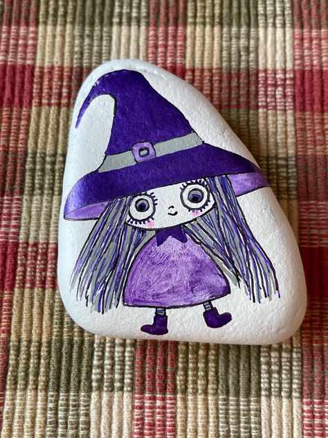 Hand painted on a river rock is a cute quirky witch done in partial metallic purples.  This would make a perfect addition to your Halloween or fall decor. Measures: 3 " x 2 " x 1 ". Sealed with gloss varnish to help preserve the art.   Please note: the back is not painted so that you may see the raw rock. Purple Painted Rocks, Rock People, Witch Painting, Halloween Rocks, Turtle Painting, Animal Crafts For Kids, Rock Ideas, Rock Painting Designs, Rock Painting Art