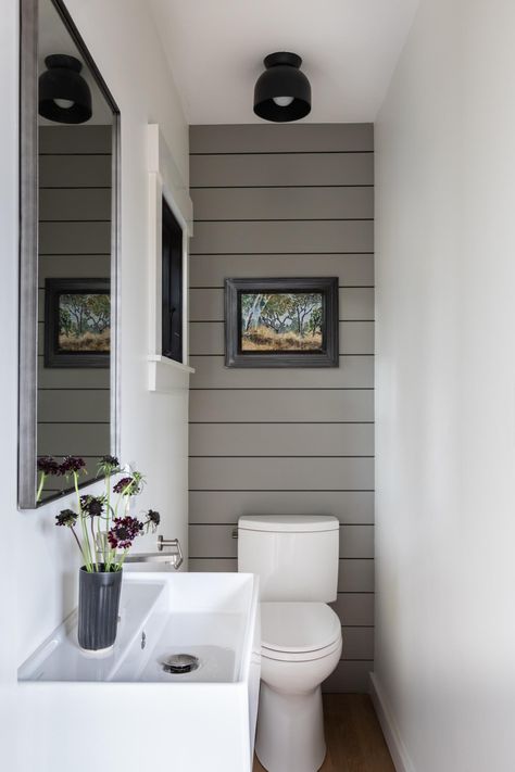 A small powder room with gray wall paneling and a small window for extra light. Tiny Powder Rooms, Small Downstairs Toilet, Bathroom Under Stairs, Powder Room Remodel, Toilet Room Decor, Small Toilet Room, Powder Room Decor, Downstairs Toilet, Powder Room Design