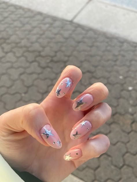 Acrylic nail design with silver stars and gems Oval Nails With Stars, Shiny Star Nails, Silver Star Acrylic Nails, Nails With Stars And Gems, Pop Star Nails, Star Nails Multicolor, Pink Glitter Star Nails, Pink And Silver Star Nails, Stars On Nails Design