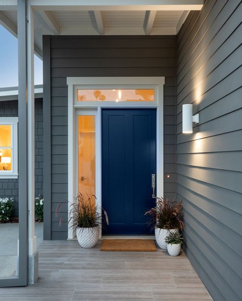 Grey house with dark blue front door, side lite and white trim. | Indoor/Outdoor Coastal Living Dark Blue Door Exterior, Grey House With Blue Door, Front Door Blue, Dark Blue Front Door Colors, Grey House Blue Door, Dark Blue Front Door, Grey House Door Color Ideas, Grey House Exterior, Grey House White Trim