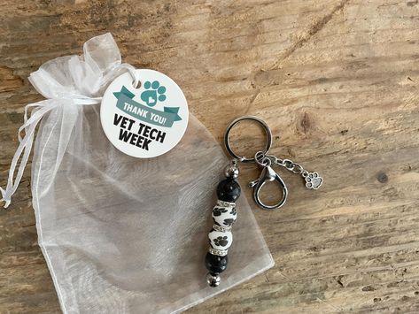 This vet tech key chain is the perfect thank you gift for Vet Tech Week 2024. A cute beaded keychain with paw prints and stethoscope or dog paw charm.  Vet Tech Week 2024 starts October 15 - 21, and these are great for VRT, CVT, DVM, emergency vet staff, animal clinic and veterinary hospital office gifts, livestock, avian vet techs and receptionists, exotic animal vet tech, large animal vet tech, equine vet tech, feline vet tech, and cat vet techs, assistants and vet receptionists! PLUS we DONATE to animals. Thank you for shopping with Because of Paws and making a difference in an animal's life. - Susan and Angela Veterinary Technician Week Gift Ideas, Large Animal Vet Tech, Equine Vet Tech, Cute Beaded Keychain, Veterinary Technician Week, Vet Receptionist, Equine Vet, Hospital Office, Animal Vet