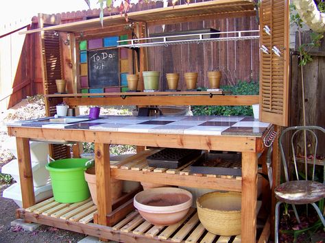 Another view of potting table made by repurposing items with inspiration from Pinterest. Potting bench repurposed from surplus items found at Urban Ore, Berkeley, CA. Shutters, Bi-fold doors, old sink, and granite scraps.  Stained glass window center was broken, so I replaced with wood and painted it with chalkboard paint. Garden Potting Bench, Potting Bench Ideas, Pallet Garden Benches, Diy Potting Bench, Potting Bench Plans, Potting Station, Outdoor Sink, Outdoor Potting Bench, Potting Benches