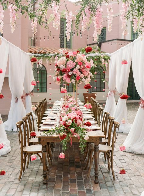 Elegant Garden Theme Wedding Reception Decor, White Drapery with Hanging Pink Flowers, Long Wooden Feasting Table with Wooden Cross Back Chairs, Tall Pink, Ivory and Red Floral Centerpiece | St. Pete Wedding Venue The Vinoy Renaissance Valentines Day Wedding Invitations, Extravagant Wedding Florals, Pink And Red Centerpieces Wedding, Valentine Theme Wedding, Valentines Themed Wedding, Valentines Wedding Theme, Valentine’s Day Wedding, Valentines Theme Wedding, Red And Blush Wedding