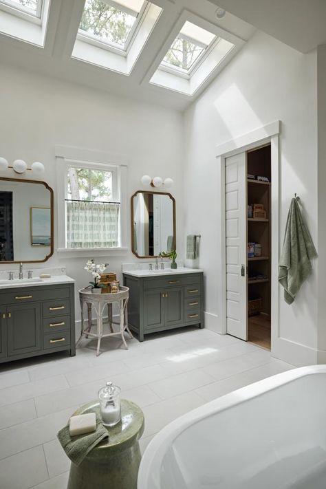 A trio of skylights in the primary bathroom draws the eye upward and brings ample natural light into the room. White tile on the floors feels fresh and modern, while green cabinetry is soothing and serene. Skylight Bathroom, Bathroom Drawing, Bluffton South Carolina, Coastal Cottage Style, Hgtv Dream Home, Bedroom Drapes, Bedroom Fireplace, House Hunters, Primary Bathroom