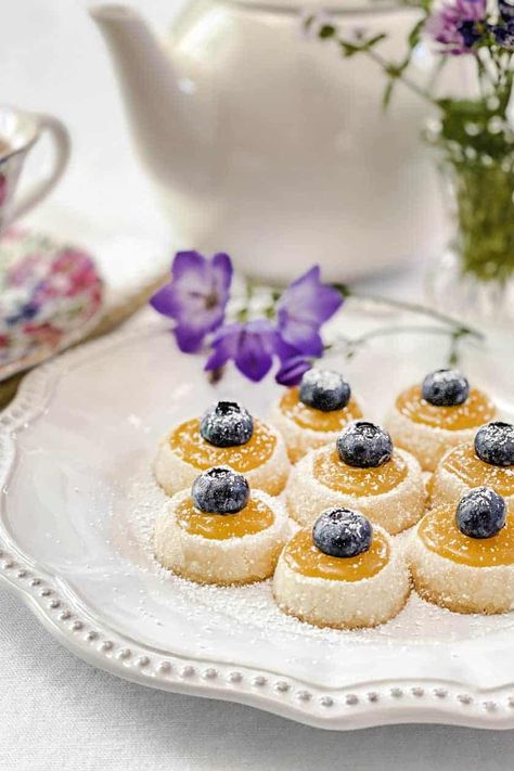 Shortbread Tea Cookies with Lemon Curd, crowned with fresh blueberries, are tiny bites of perfection. Petit and perfectly sized for afternoon tea, they are melt-in-your-mouth delicious. Afternoon Tea Cookies, Cookies With Lemon Curd, Lemon Curd Dessert, Cookies With Lemon, Tea Party Desserts, Tiny Bites, Baked Apple Dessert, Afternoon Tea Recipes, Lemon Curd Recipe