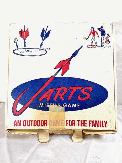 1960's - Vintage Advertising Jarts Missile Lawn Darts Game for the FamilyDimensions: 15 " x 14 1/2"  (also known as Javelin darts, lawn or yard darts) A lawn dart set usually includes four large darts and two targets. The game play and objective are similar to both horseshoes and darts.They are typically 12 inches (30 cm) long with a weighted metal or plastic tip on one end and three plastic fins on a rod at the other end. Jarts Lawn Darts, Lawn Darts, Dart Set, Heddon Lures Vintage, State Of Arizona, Retro Pop, Outdoor Games, Christmas Kitchen, Online Auctions