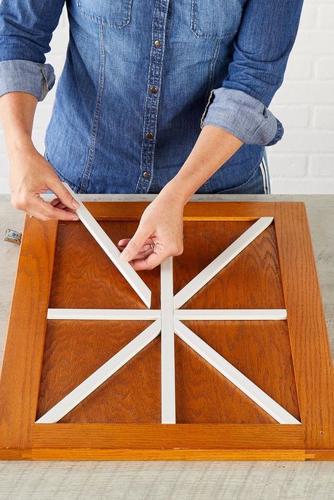 Banish boring kitchen cabinets with DIY farmhouse cabinets that complement your rustic kitchen decor. This easy project employs wood trim to create a barn door-inspired design across the cabinet front. #farmhousediy #farmhousekitchen #kitchencabinet #cabinetideas #bhg Diy Kitchen Cabinet Doors, Cabinet Door Makeover, Modern Rustic Kitchen, Kitchen Shutters, Barn Door Cabinet, Making Barn Doors, Rustic Kitchen Tables, Diy Cabinet Doors, Farmhouse Cabinets