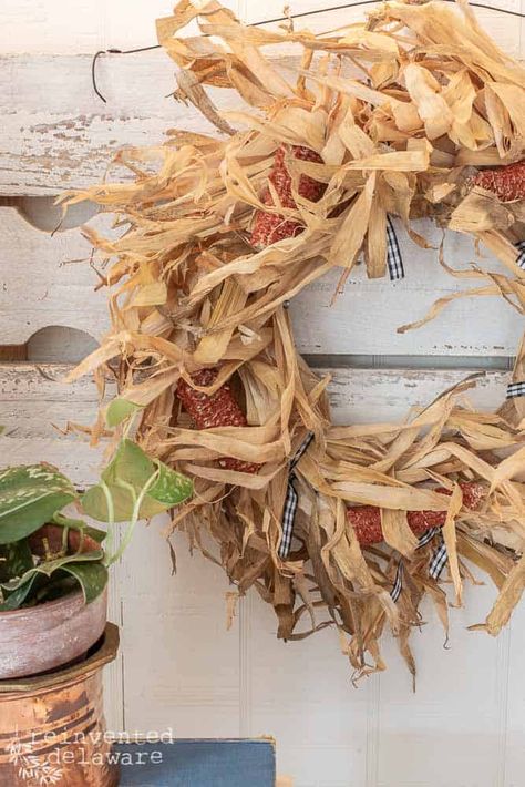 corn husk wreath with corn cobs hanging on a wall with a green plant on the side Cheap Wreaths, Inexpensive Wreaths, Corn Husk Wreath, Corn Husk Crafts, Blue Fall Decor, Easy Corn, Corn Husks, Diy Straw, Easy Fall Wreaths