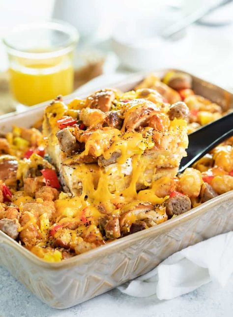 A spatula pulling up a slice of everything bagel breakfast casserole from casserole dish with orange juice in background. Everything Bagel Breakfast Casserole, Bagel Casserole, Bagel Breakfast Casserole, Everything Bagel Breakfast, Breakfast Eggs Scrambled, The Cozy Cook, Bagel Breakfast, Cozy Cook, Breakfast Bagel