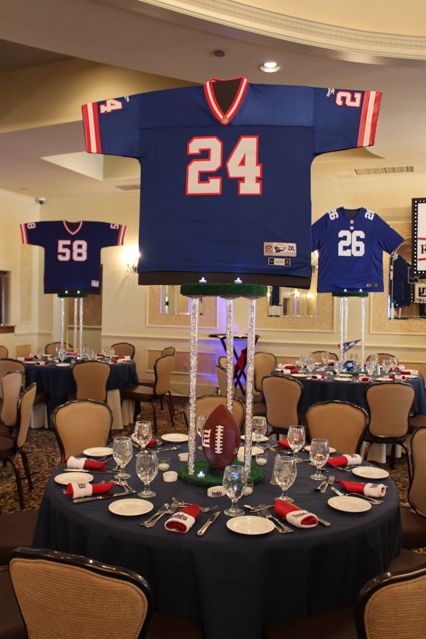 Football Sports Jersey Centerpieces with Sports Equipment... looks like just foam board holding the jerseys. Sports Themed Centerpieces, Football Banquet Centerpieces, Football Centerpieces, Sports Centerpieces, Soccer Banquet, Themed Centerpieces, Banquet Centerpieces, Cheer Banquet, Football Banquet