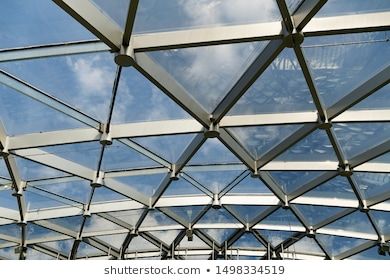 Futuristic metal and glass roof design close-up. Modern ceiling with elements of glass, metal mesh. Blue sky.  photo Royalty free images stock Glass Roof Design, Glass Ceiling Design, Futuristic Garage, Office Building Architecture, Glass Structure, Roof Construction, Sky Photo, Space Frame, Building Architecture