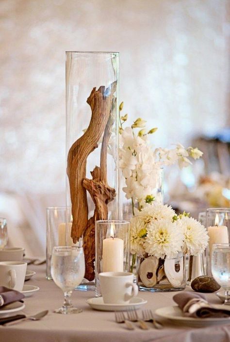 a beach wedding centerpiece of white blooms, seashells, candles and driftwood in a tall jar looks spectacular Driftwood Wedding, Driftwood Centerpiece, Beach Wedding Centerpieces, Wedding Cakes Blue, Beach Wedding Decorations, Coastal Wedding, Beach Theme Wedding, Nautical Wedding, Wedding Flower Arrangements