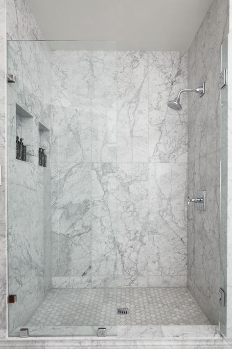 Marble is an exquisite stone that embodies the beauty of nature. With its beautiful veining and patterns, it is sure to capture attention in any application. Large Format Bianco Carrara tile creates a sophisticated look in this shower of a historic home. Tap the photo to learn more. #whitemarble #marbleshower #whitemarbletile Marble Tile Shower, Carrara Bathroom, Carrera Marble Bathroom, Marble Accent Wall, White Marble Shower, Marble Shower Walls, Carrara Marble Bathroom, Marble Shower Tile, Carrara Tiles