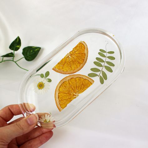 A clear resin oval tray with orange slices and white daisies embedded inside. Dehydrated Oranges, Resin Trinket Tray, Resin Fruit, Resin Home Decor, Marietta Georgia, Flower Confetti, Floral Resin, Resin Tray, Boho Room Decor