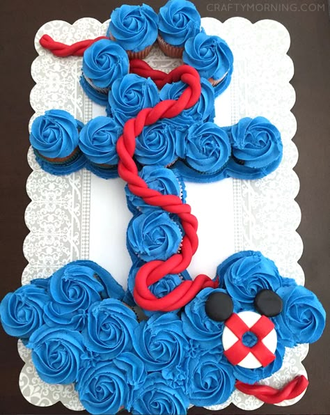 This anchor cupcake cake is just gorgeous made by N and L Sweet Treats! It was made for a baby shower with a mickey mouse theme as you can see with the little floatie in the bottom corner. You will need 26 blue frosted cupcakes to make it. Here’s a free anchor cupcake cake template … Anchor Cupcakes, Nautical Baby Shower Boy, Pull Apart Cakes, Anchor Theme, Pull Apart Cupcake Cake, Pull Apart Cake, Ahoy Its A Boy, Cake Templates, Pull Apart Cupcakes