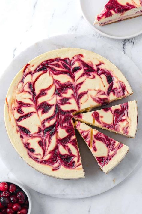 This velvety cranberry cheesecake has delicious sweet-tart cranberry swirls throughout. It's perfect for holiday hosting and is sure to wow your guests! | Cranberry Swirl Cheesecake | Cranberry Cheesecake | Cheesecake Recipe | Marbled Cheesecake, Holiday Cheesecake, Lemon Raspberry Cheesecake, No Bake Vanilla Cheesecake, Berry Coulis, Cranberry Cheesecake, Swirl Cheesecake, Lemon Dessert Recipes, Raspberry Cheesecake