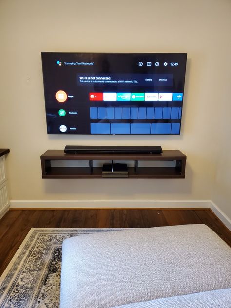 65" LG TV wall mounted above floating audio visual cabinet. Tv Attached To Wall, Bedroom Ideas For Tv On Wall, 70 Inch Tv Mounted On Wall, Mounted Tv With Game System, Hang Tv On Wall Ideas Living Rooms, Boys Bedroom Tv Wall, 50 Inch Tv On Wall, Tv Box Wall Mount, Tv Mounted On The Wall In Bedroom