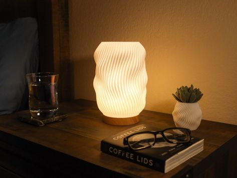 "This ridged design of this desk lamp creates an elegant pattern of light. The soft light will accent any desk or surface and compliments a modern theme. - 3D printed to order from PLA plastic with a wooden base - The light source is an energy efficient LED, and is USB powered. - Includes a block to use in any standard outlet. - The lamp is 8\" tall and 6\" wide (4\" wide wooden base)" Quail House, Desk Lamp Design, Mid Century Modern Lamps, Drukarka 3d, 3d Lamp, Standard Lamps, Round Rock, Elegant Pattern, Desk Light