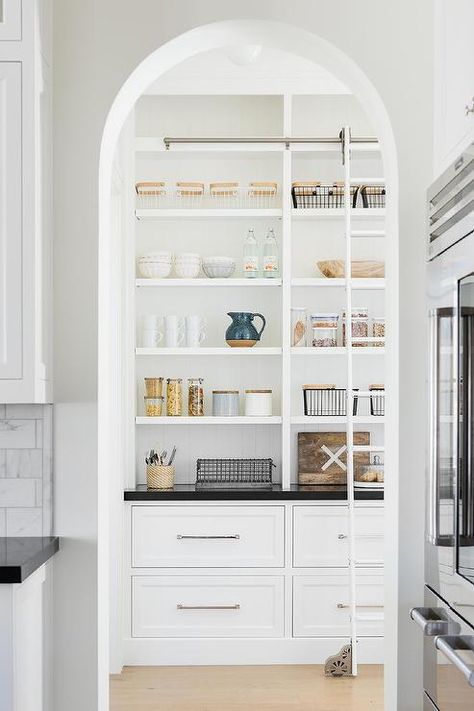 Arched doorway into a custom pantry featuring a ladder on rails on a built-in shelf with black quartz countertops. California Traditional Home, Traditional Interior Design, Butler's Pantry, Studio Mcgee, Pantry Design, Modern Country, Open Kitchen, White Cabinets, Interior Design Studio