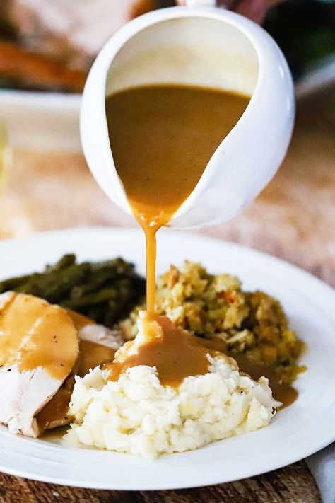 A white gravy boat pouring turkey gravy over a plate of mashed potatoes, dressing, turkey, and green beans. Thanksgiving Gravy Recipes, Brown Gravy Recipe Easy, Easy Brown Gravy, Make Ahead Turkey Gravy, Best Turkey Gravy, Turkey Gravy From Drippings, Brown Gravy Recipe, Homemade Gravy Recipe, Gravy From Scratch