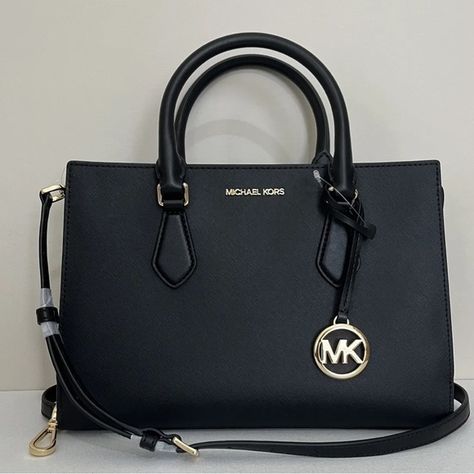 Shop amstar13's closet or find the perfect look from millions of stylists. Fast shipping and buyer protection. New with tags 100% Authentic Michael Kors Sheila Medium Saffiano Leather Satchel Black with Gold tone hardware Style# 35S3G6HS2L Elegantly streamlined, the Sheila satchel is a classic style you can carry all day and into the night. It’s crafted from faux Saffiano Leather with minimal hardware and has internal pockets for organizing your belongings. Carry it by the elegant top ha Black Purse Designer, Michael Kors Handbags Black, Michael Kors Bag Black, Closet Basics, Trendy Purses, Michael Kors Satchel, Black Leather Bag, Black Satchel, Leather Duffle Bag