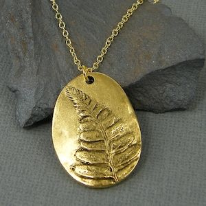 Gold fern necklace. Necklace features a raised fern leaf pendant. Pendant is made of 24KT gold plate over pewter. Pendant is 1 1/4 inches tall, 7/8 inches wide.

Your choice of chain length - 18 or 20 inches. Chain length on mannequin is 18 inches. Fern Necklace, Necklace Leaf, Fern Leaf, Pewter Pendant, Pendant Necklace Gold, Newport News, Necklace Necklace, 24kt Gold, Leaf Pendant