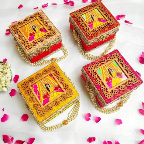 These beautifully decorated boxes appear to be traditional Indian wedding favors or return gifts, often given to guests at celebrations like weddings, baby showers, haldi/mehndi ceremonies, housewarming parties, and festive gatherings. The intricate designs featuring figures in vibrant colors, embellished with metallic accents and floral motifs, showcase the rich cultural heritage and artistry associated with such occasions. These favors would make lovely mementos for attendees to cherish the... Haldi Gifts For Guests, Indian Wedding Return Gifts, Wedding Return Gifts, Rakhi Festival, Decorated Boxes, Indian Wedding Favors, Wooden Trunk, Mehndi Ceremony, Wooden Trunks