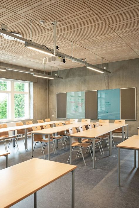 Acoustic ceiling panels in the design solution Troldtekt line are used throughout this school building. The dynamic feel of the ceiling and the wood colour contrast beautifully with the concrete, and the precision of the lines and the varying patterns are also ideally suited to counterbalance the raw walls. #goodacoustics #holzwolleplatten #träullsplattor #acousticpanels | Architects: Mangor & Nagel arkitekter Classroom Lighting Design, Adult Classroom Design, School Ceiling Design, Scandinavian Classroom, Classroom Wall Design, School Interior Design Classroom, Interior Design Classroom, School Classroom Design, Classroom Interior Design