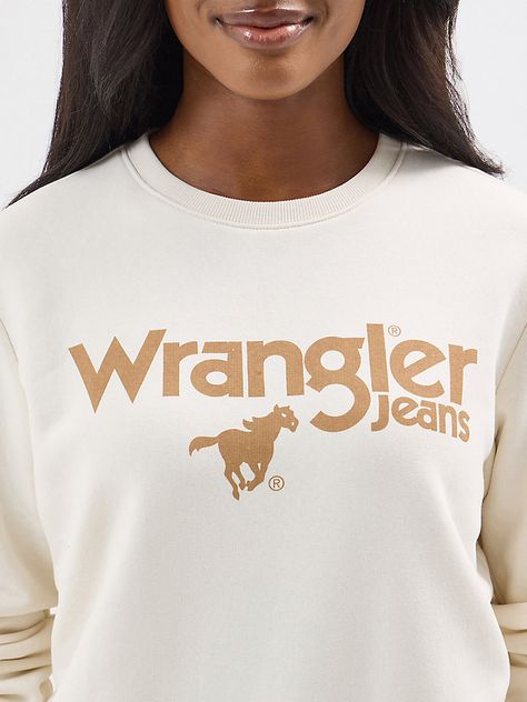 Cozy up when it’s cold in our Women’s Wrangler Retro® Crewneck Sweatshirt. This pullover is crafted from a comfortable cotton blend to keep you warm. It features a retro-inspired graphic of a cowboy roping a steer across the front for a Western-inspired look. Not too tight or loose, this sweatshirt’s regular fit will feel as if it were made just for you. Wrangler Sweatshirt, Cowboy Roping, Retro Crewneck, Men Workwear, Custom Design Shirts, Whisper White, Women Long Sleeve Tops, Womens Tights, Clothing Co