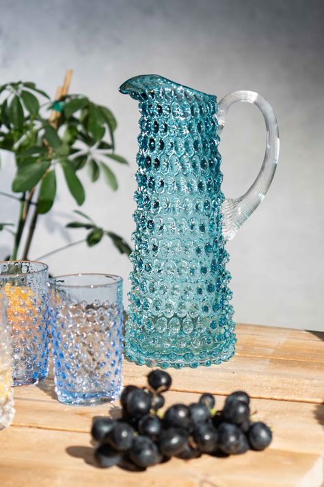 Tall hobnail pitcher in light turquoise colour with two light blue tumblers. The set is on a wooden table with purple grapes in front of the glassware. There's a grey wall behind the glassware and a plant. Matching Tumblers, Long Stem Flowers, Turquoise Decor, Bohemian Crystal, Glass Jug, Centre Stage, Glass Pitcher, The Dinner, Spring Aesthetic