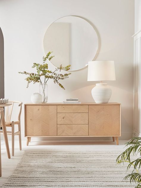 The perfect sideboard for a neutral or Scandi inspired interior, our stylish blonde oak piece features four slender, tapered legs and a subtle chevron finish.  Each piece has three handy drawers for ample storage, and pairs beautifully with other pieces from our Chevron Oak Furniture Collection.  Try styling your sideboard beneath a classic round mirror . Scandi Sideboard, Uk Living Room, Scandi Office, Danish Living Room, Sideboard Styling, Light Oak Furniture, Scandi Living Room, Sideboard Styles, Scandi Living