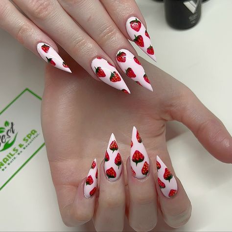 Looking for a fun and playful nail design for summer? Look no further than our strawberry nail design! Our expert nail technicians at the best nail salon in Phoenix have created a stunning look that is sure to make your hands pop. Featuring a bright red base color and delicate white polka dots, this design is topped off with adorable strawberry accents on each nail. Perfect for a day at the beach or a summer picnic, this strawberry nail design is a must-try for anyone looking to add a touch of s 4th Of July Strawberry Nails, White Strawberry Nails, White Nails With Strawberries, Strawberry Nails Acrylic Long, Strawberry Nails Stiletto, Stiletto Nails Summer, Pink And Red Strawberry Nails, Nail Design For Summer, Strawberry Accent Nail