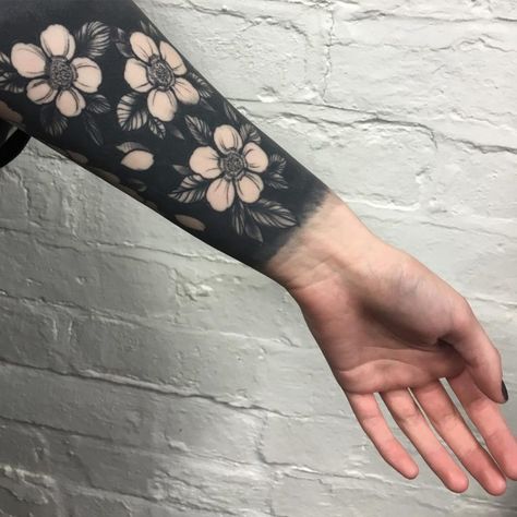 Negative space black flowers tattoo Negative Tattoo, Black Flowers Tattoo, Negative Space Tattoo, Wrist Tattoo Cover Up, Solid Black Tattoo, Black Tattoo Cover Up, Tattoo Filler, Tattoo Background, Blackout Tattoo