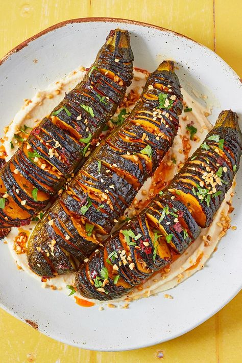 Crispy on the outside and meltingly tender on the inside, our hasselback courgette recipe is a summery, vegan treat. Packed with flavour, the dish contains hot harissa, creamy tahini and a spicy dukkah topping for a little crunch. This is one of our favourite summer vegan recipes – click the link for more. Courgette Vegan Recipe, Healthy Courgette Recipe, Vegan Chef Recipes, Vegan Courgette Recipe, Harissa Zucchini, Courgettes Recipes, Summer Dishes Dinner, Summer Vegan Recipes, Courgette Recipe