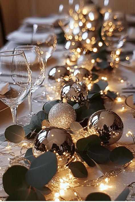 Create a stunning table runner with ornaments, greenery, and fairy lights. This versatile centerpiece adds a touch of elegance to any holiday gathering. Get the full tutorial now! Some of the links in my articles are affiliate links. If you make a qualified purchase from one of my links I will make a small commission at no cost to you. Thank you for your support!!! Table Setting With Fairy Lights, Hunter Green Christmas Table Decor, Christmas Table Centerpieces Baubles, Christmas Table With Poppers, Fairy Lights Table Runner, Winter Banquet Centerpieces, Ornament Table Runner, Christmas Banquet Round Table Decorations, Christmas Table Black And Gold