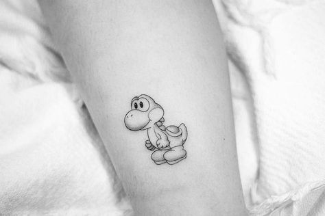 Small Yoshi Tattoo, Yoshi Outline, Yoshi Tattoo Black And White, Funny Small Tattoos, Super Mario Tattoo, Groot Tattoo, Nintendo Tattoo, Cartoon Tattoo Ideas, Video Game Tattoos