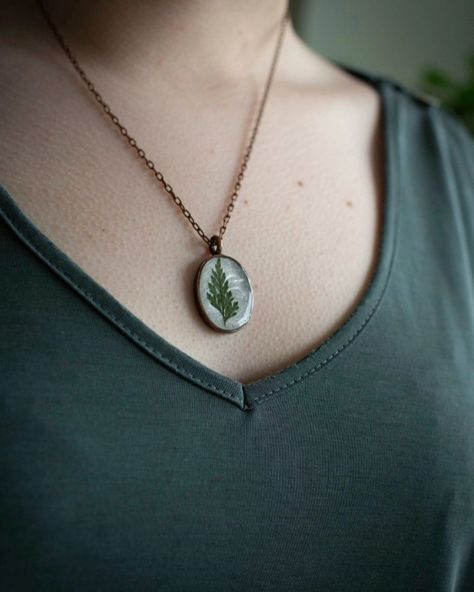 Ferns whisper of resilience and renewal, their delicate fronds unfurling in hidden corners to remind us that even in the shadows, life finds a way to flourish. Ferns symbolize new beginnings, growth, and the quiet strength to thrive in unexpected places. They represent the beauty of perseverance and the mysterious, enduring cycles of life. Handmade fern necklace www.sweetellabella.com #botanicaljewelry #sweetellabellabotique #handmadenecklace #spousely Life Finds A Way, Cycles Of Life, Fern Necklace, Resin Pendant Necklace, Cycle Of Life, Wife And Kids, Botanical Jewelry, In The Shadows, The Quiet