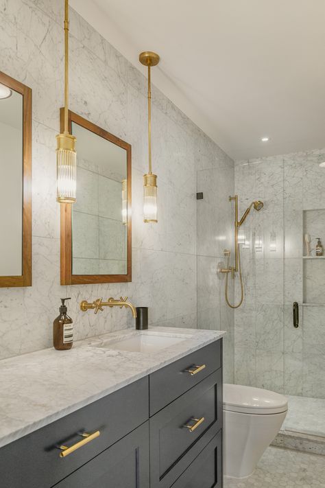 The master bathroom features a simple palette of walnut, brushed brass, marble, and dark gray cabinets. #masterbathroom #interiordesign #remodelideas #boardandvellum Marble And Brass Bathroom, Dark Gray Cabinets, Grey Marble Bathroom, Brushed Brass Bathroom, Grey Bathroom Cabinets, Dark Gray Bathroom, Condo Bathroom, Marble And Brass, Modern Condo