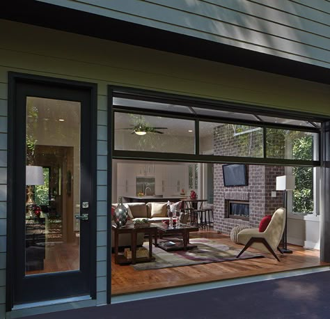 This family room in LaVista Park easily opens to the outdoors with a retracting glass garage door, inspired by the home’s modern-industrial look. Rinnovo Garage, Garage To Living Space, Garage Floor Paint, Garage Door Styles, Garage Loft, Garage Renovation, Garage Room, Glass Garage Door, Garage Door Makeover